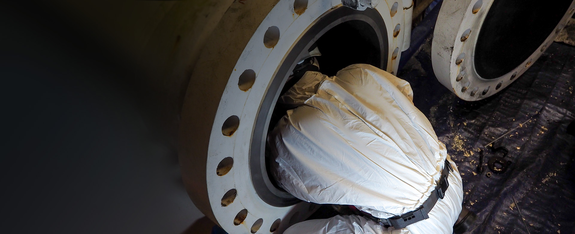 worker in protective gear entering a confined space